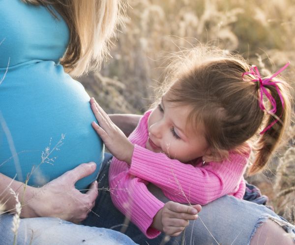 Fetita care atinge burta insarcinata a mamei, program pentru sarcina si alaptare, cu consilier in nutritie Roxana Ciocaltea, Nutritie cu Roxi